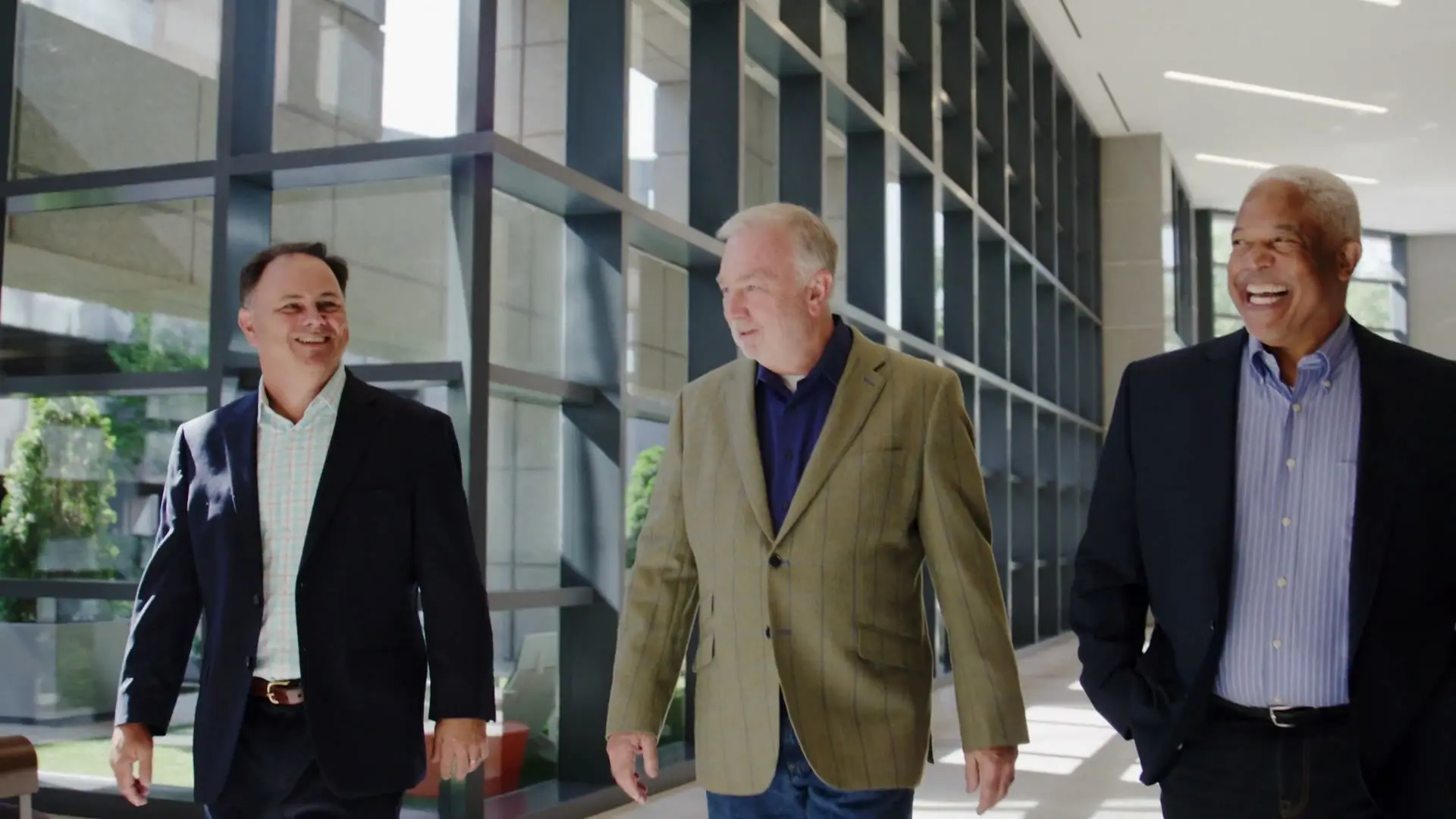 John Charleston, Tony Samples, and Phil Eleson laughing together in an Alpharetta office lobby