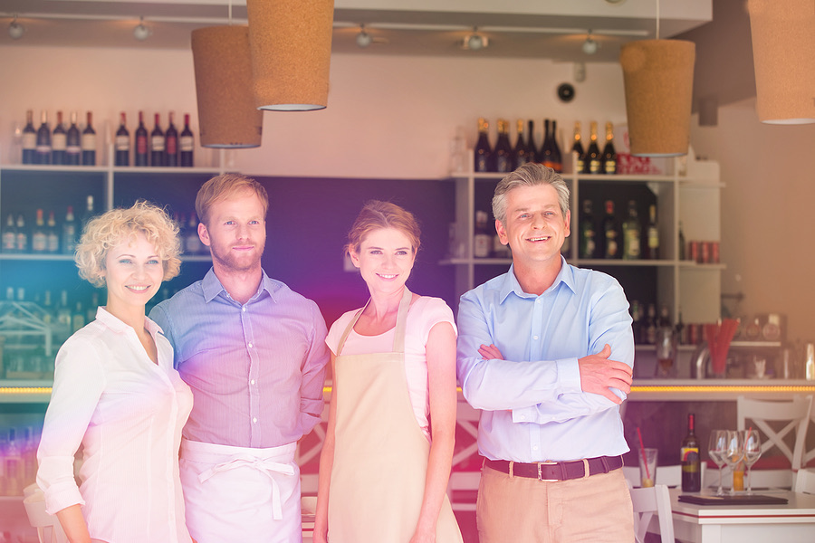 Family business owners standing together behind the bar