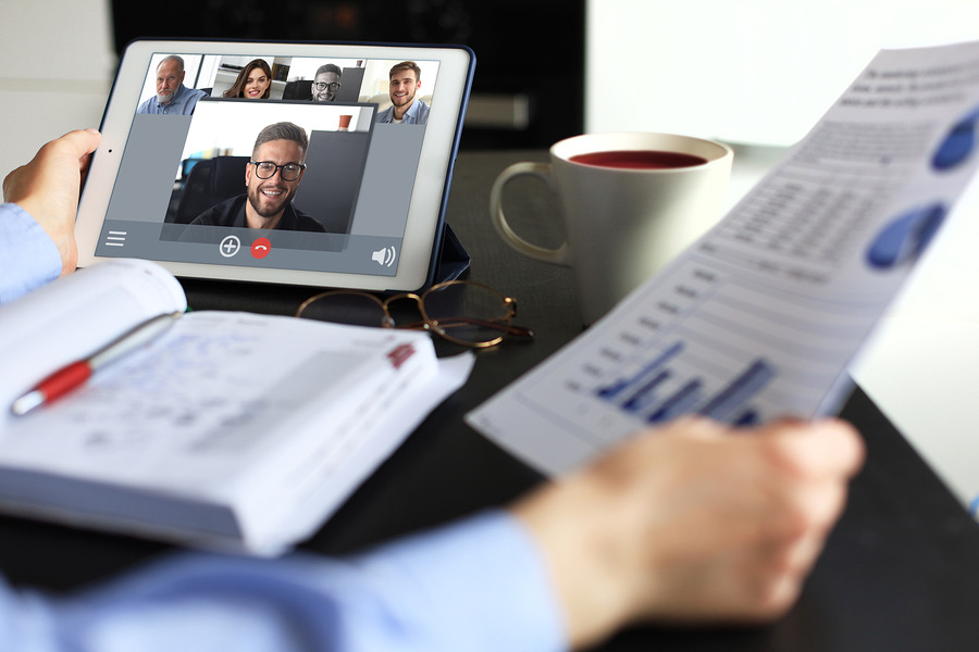 Person on a video call with colleagues while reviewing a report