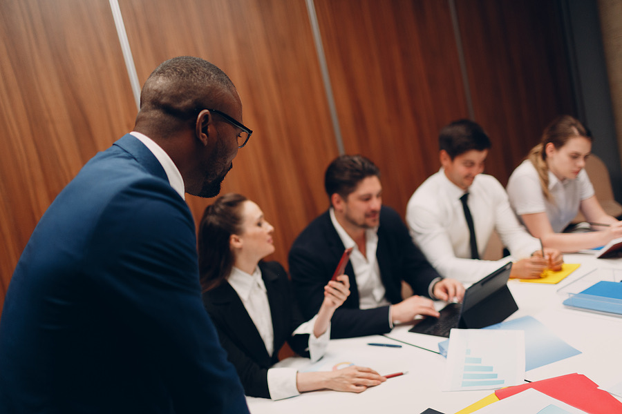 Business owner addressing his team seated around a conference table