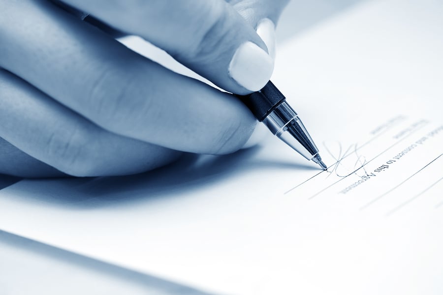 Close-up of a hand signing a contract