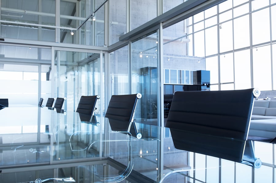 Empty conference room with black chairs and glass walls