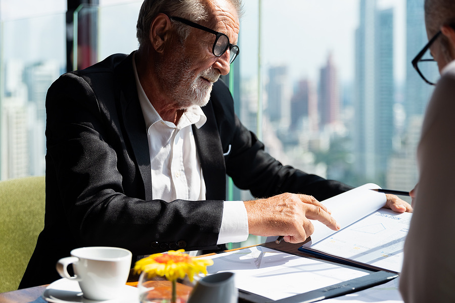 Senior business owner reviewing a document with a colleague