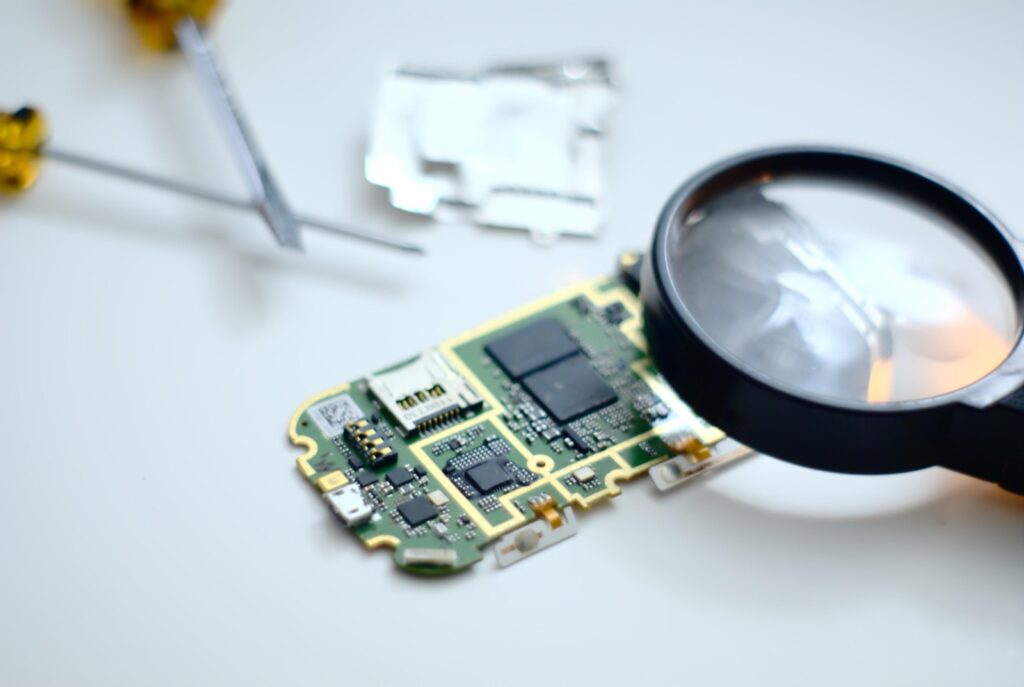 Circuit board inspected closely with a magnifying glass
