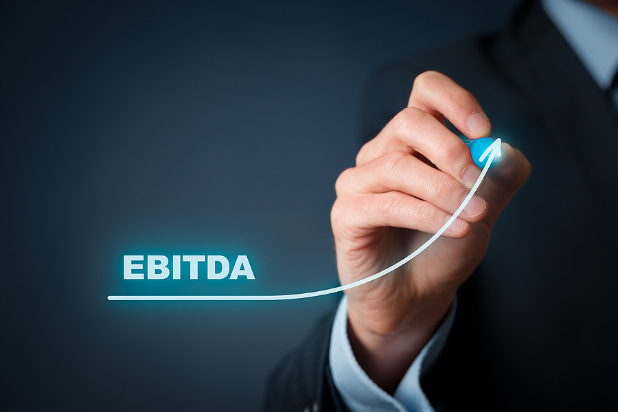 Businessman drawing an upward arrow above the word EBITDA