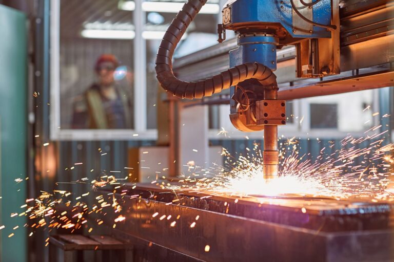 Laser cutting machine throwing sparks on a manufacturing floor