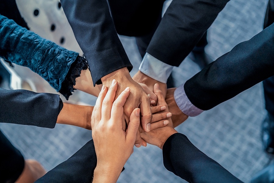 Colleagues stacking hands together in a team huddle