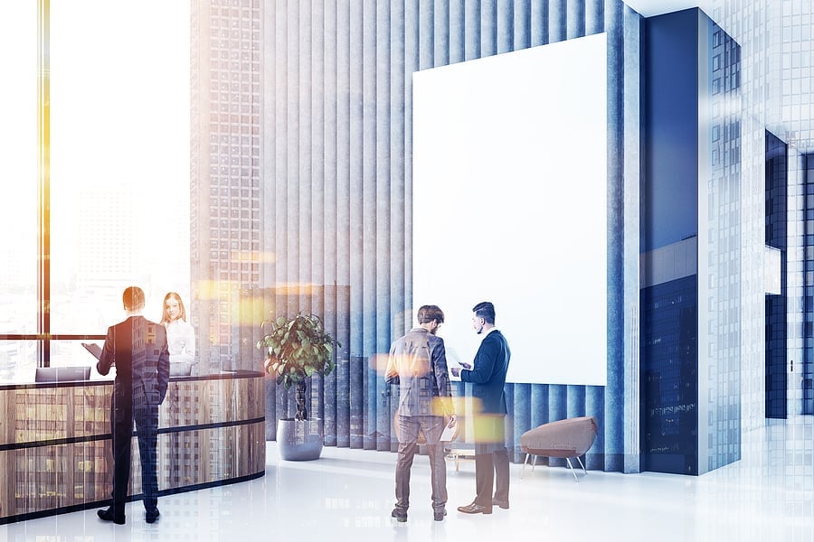 Colleagues talking near a reception desk in a bright lobby
