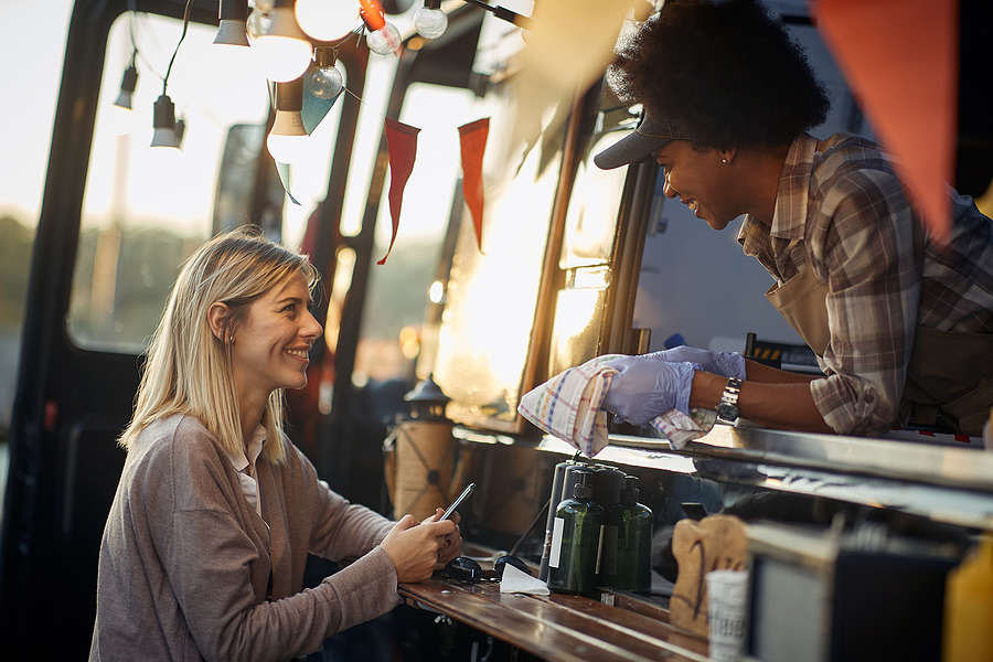 Customer smiling while ordering at a food truck window