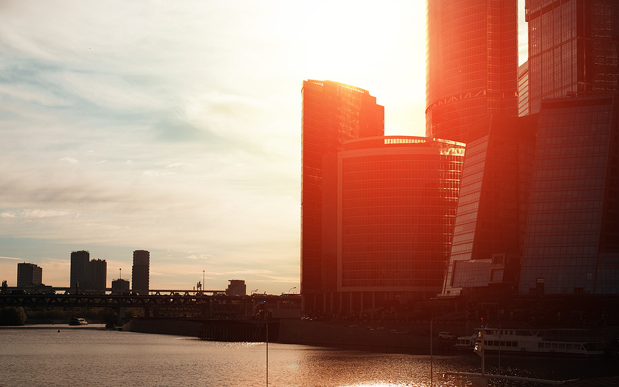 Silhouette of city office towers backlit by sunset