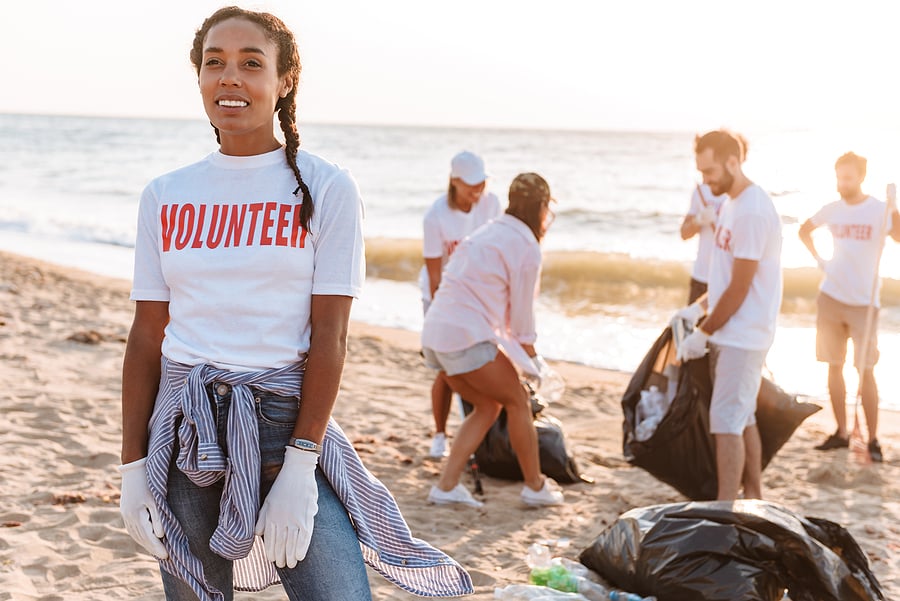 Volunteer smiling on a beach during a group cleanup