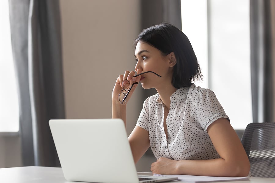 Business owner looking thoughtfully at a laptop screen