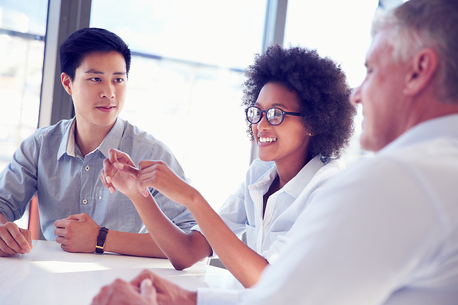 Three professionals discussing business at a conference table