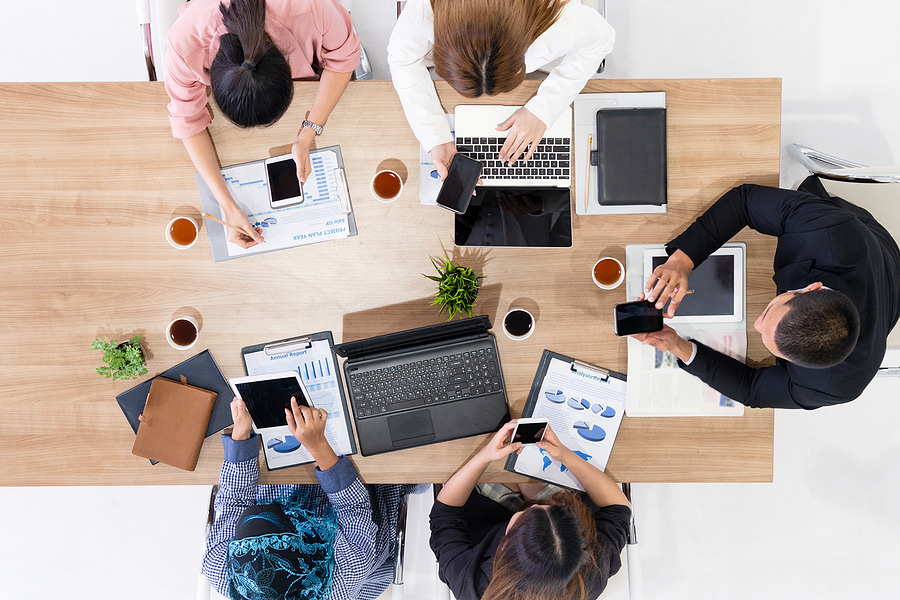 Overhead view of a team working with laptops and tablets