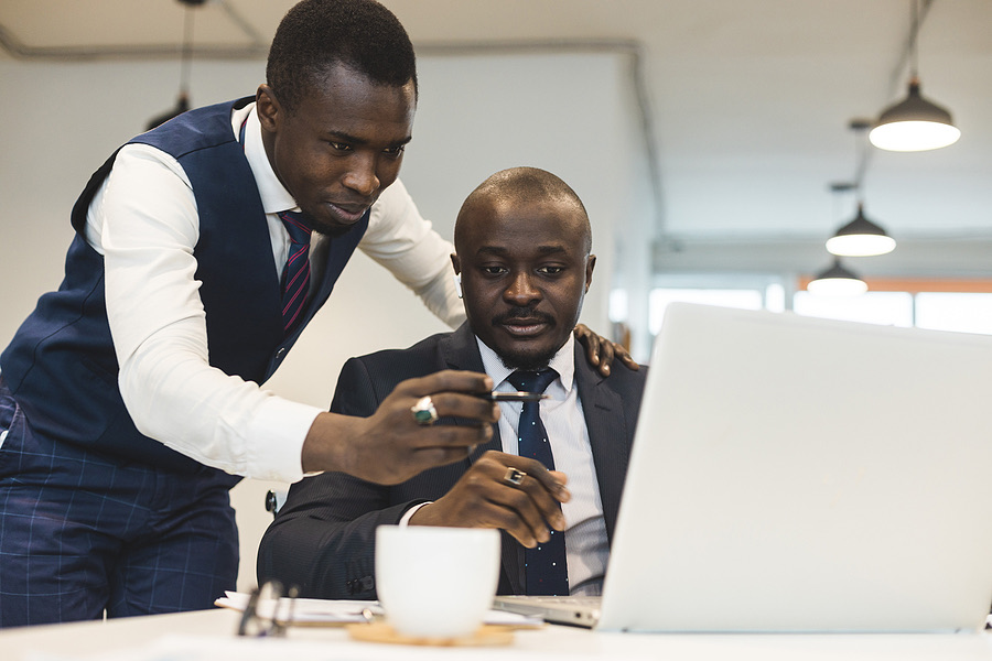 Two colleagues reviewing information together on a laptop