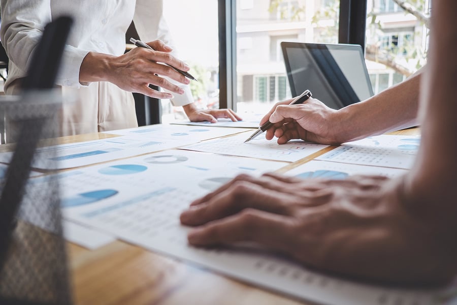 Colleagues reviewing charts and reports at a table