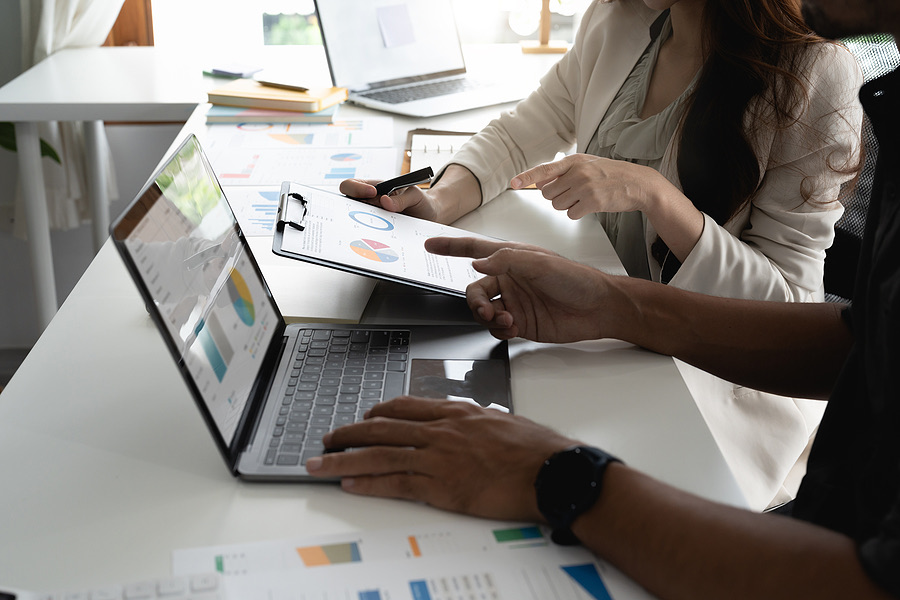 Colleagues reviewing investment charts on a laptop