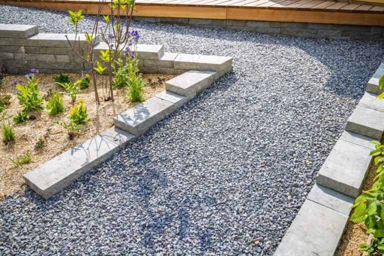 Landscaped garden with a grey gravel path, stone edging, and plantings